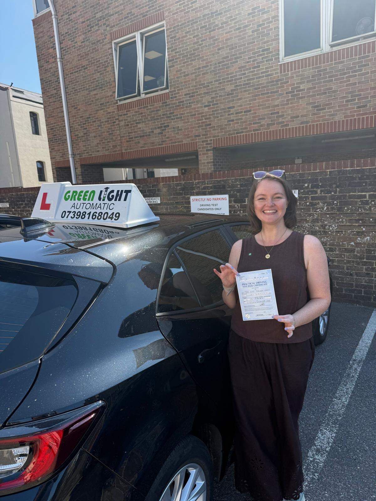 Learner holding a driving test pass certificate